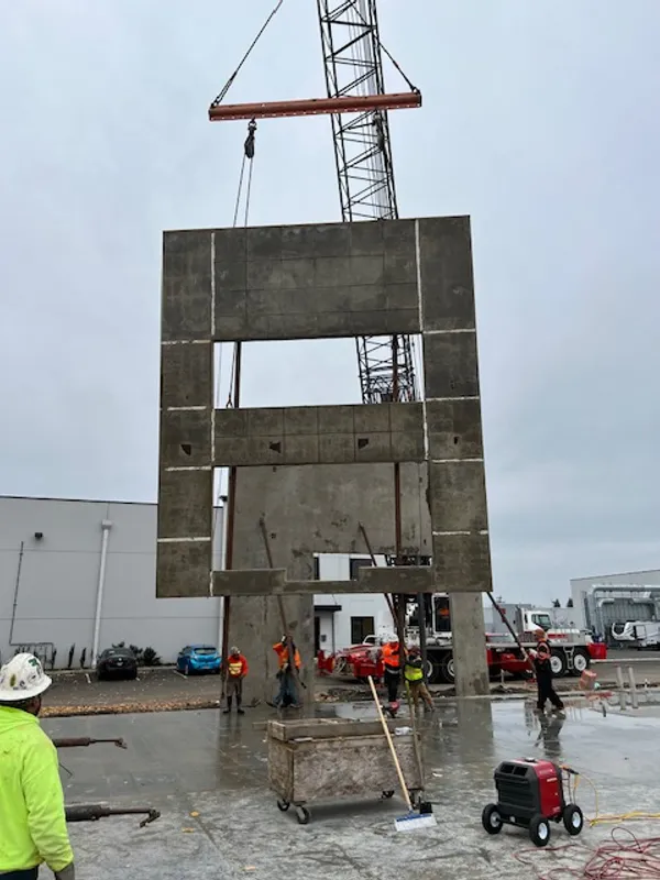Large precast concrete panels hoisted into place by crane